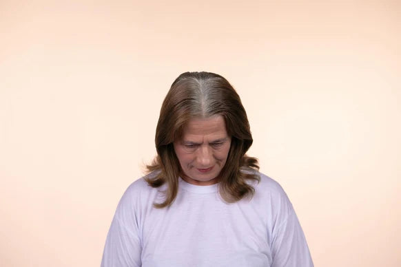 Before powder application, visible lighter roots along a brown-haired parting